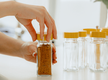 A woman using glass jars to organize spices