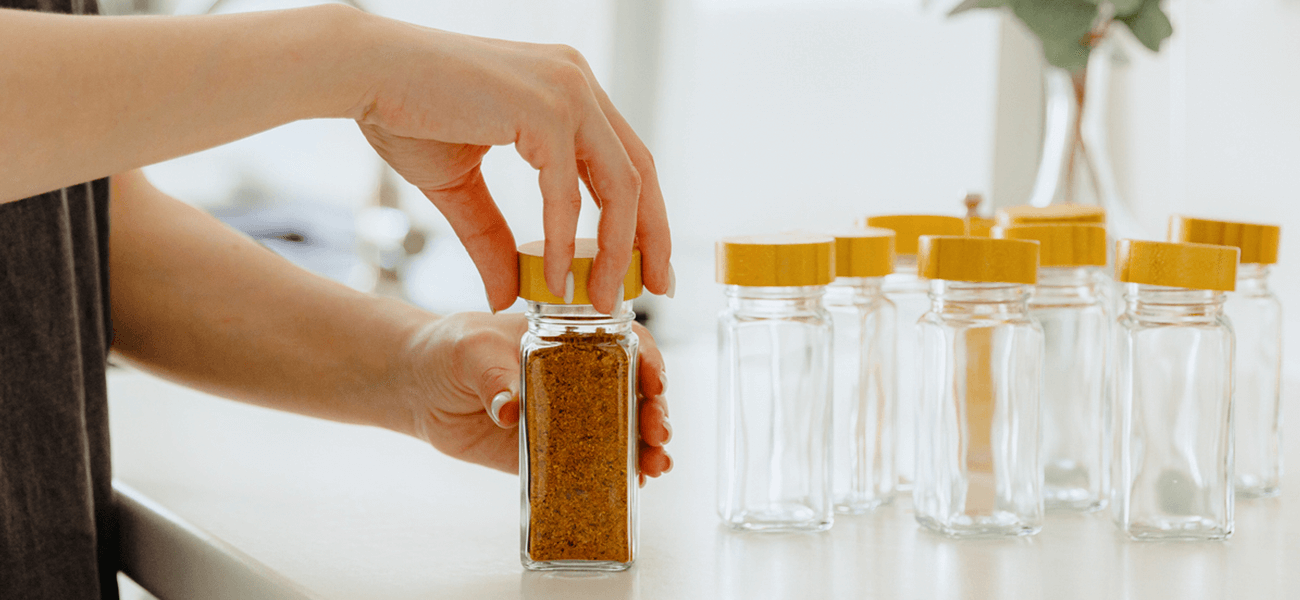 A woman using glass jars to organize spices